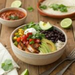 A colorful spread of burrito and taco bowls with fresh toppings, including avocado, beans, grilled chicken, and tortilla chips.